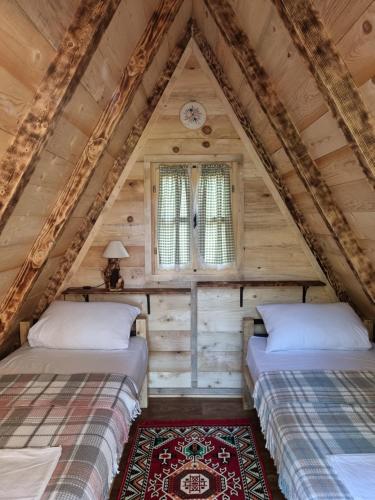 two beds in the attic of a log cabin at Camp Wolf & Sheep- Nature & Adventure in Podgorica