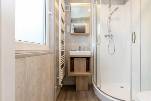 a bathroom with a sink and a shower at NATURAMA Brombachsee Tinyhaushotel in Pleinfeld