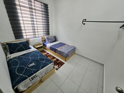 two beds sitting in a room with a window at Razumi's Homestay 2 in Arau