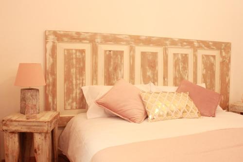 um quarto com uma cama com uma cabeceira e almofadas de madeira em Lanui Guest House em Sintra