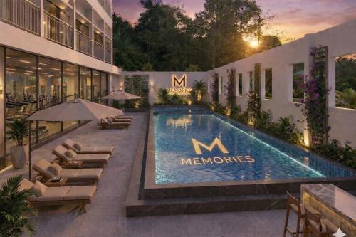 a hotel with a swimming pool and chairs and a building at Memories Hotel in Bảo Lộc