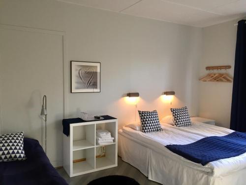 a small bedroom with two beds and a night stand at Aurora Bed & Breakfast in Simrishamn