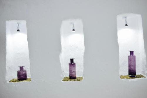 a group of four purple vases on a wall at Cuevas Helena in Benamaurel