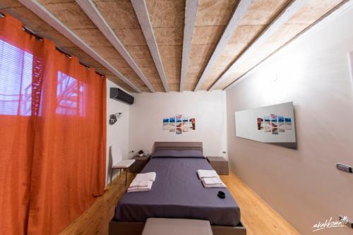 Habitación con 2 camas y cortinas de color naranja. en B&B La Terrazza di Corte Sant'Anna, en Galatone