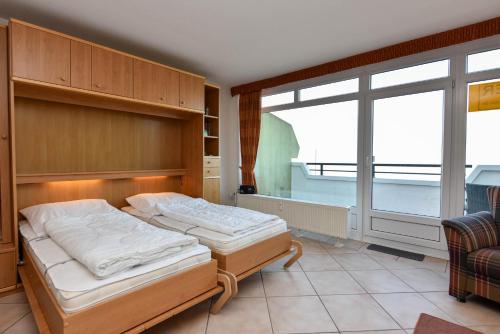 a bedroom with two beds and a window at Haus "Panorama" Appartement PAN024 in Duhnen