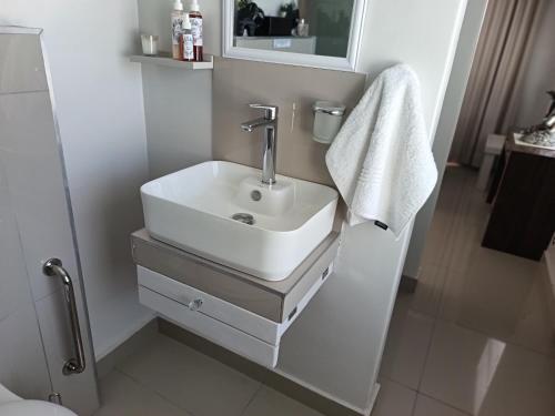 a bathroom with a white sink and a mirror at Agulhas Splendour in Agulhas