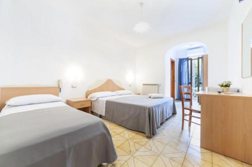 a hotel room with two beds and a kitchen at Hotel Casa Cigliano in Forio d'Ischia