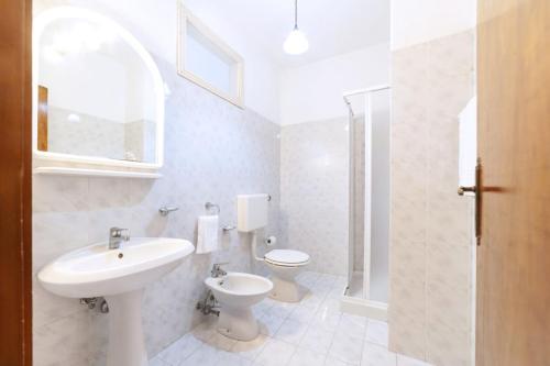 a white bathroom with a sink and a toilet at Hotel Casa Cigliano in Forio d'Ischia