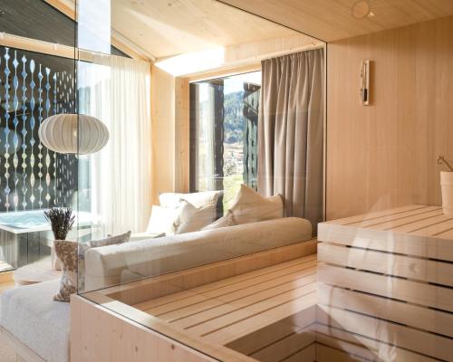 a living room with a couch and a window at Anton & Cilli Hideaway Lodges in Obermaiselstein