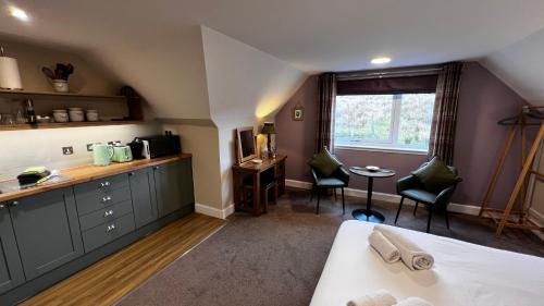 a room with a bed and a table and chairs at Springburn Farmhouse in Spean Bridge