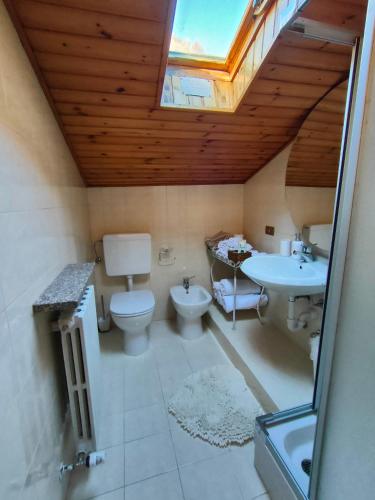 une salle de bains avec toilettes, lavabo et puits de lumière dans l'établissement Bed&Breakfast Angela, à Clusone