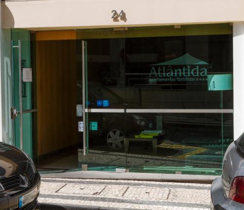 a car reflection in a glass door of a car dealership at Apartamentos Turisticos Atlantida in Funchal