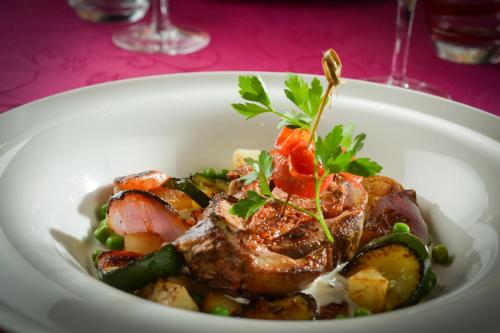 a white bowl of food with meat and vegetables at Le Domaine Des Chevaliers De Malte in Villedieu-les-Poëles