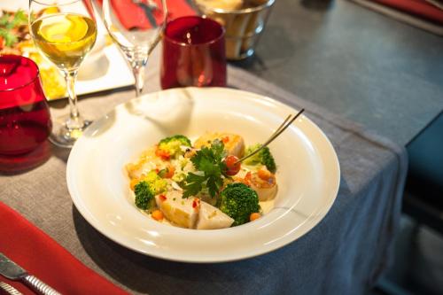a plate of food with broccoli and meat on a table at Le Domaine Des Chevaliers De Malte in Villedieu-les-Poëles