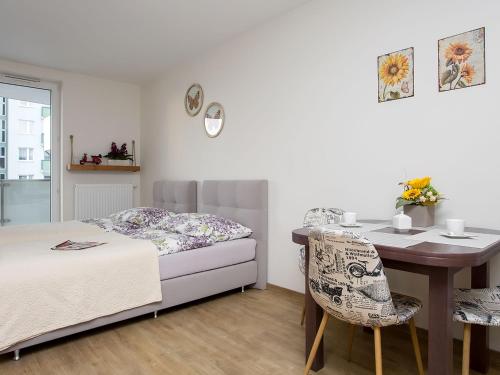 ワルシャワにあるManhattan Place Apartamentのベッドルーム1室(ベッド1台、テーブル、椅子付)
