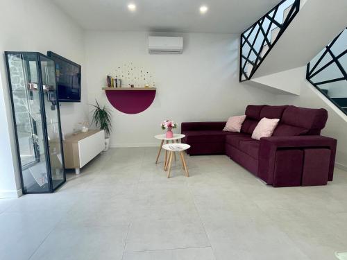 a living room with a purple couch and a table at Casa das Abelhas in Arcos de Valdevez