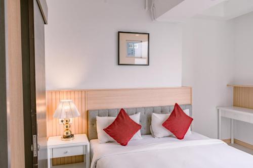 a bedroom with a bed with red pillows at Orbit House in Bandung