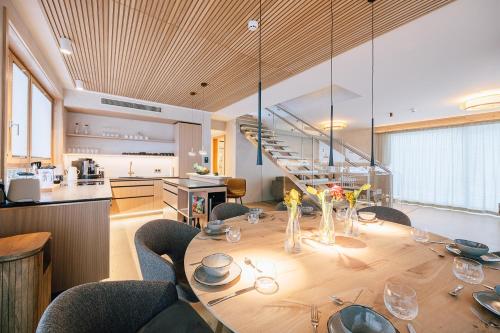 a large wooden table with chairs and a kitchen at Insel der Sinne See-Chalets in Görlitz