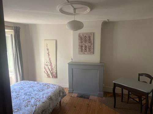 a bedroom with a bed and a table and a desk at Le Refuge du Cap in Cescau