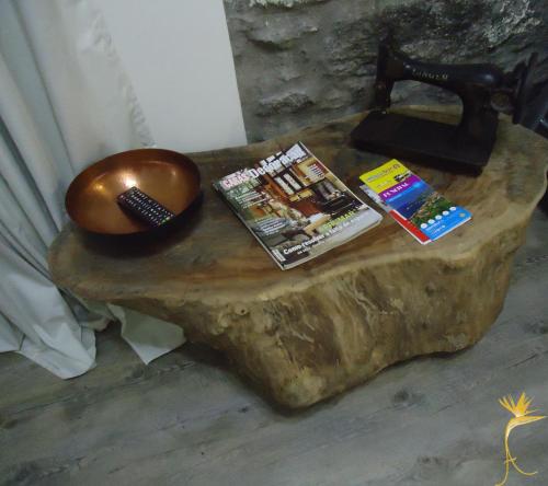 a wooden table with a telephone and magazines on it at A Casa Estrelícia-Dourada Garcês in São Vicente