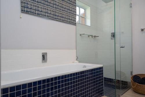 a bathroom with a tub and a glass shower at No 5 Cockleshell in Westbrook
