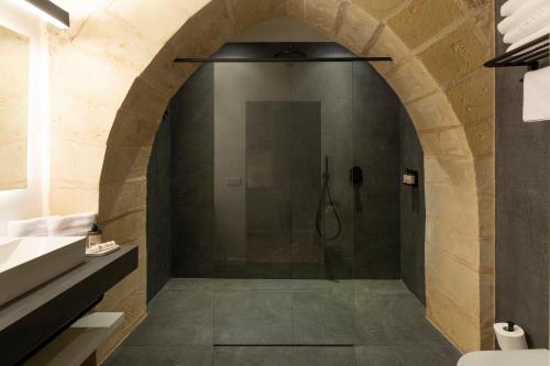a shower in a bathroom with a stone wall at Hotel Can Cirera in Palma de Mallorca
