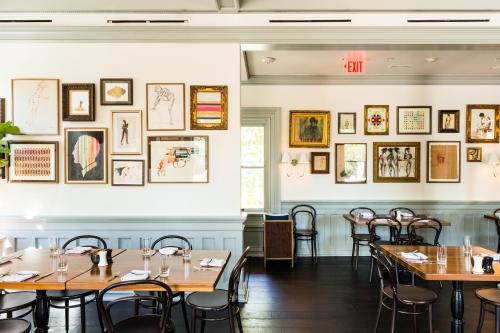 a row of tables in a restaurant with pictures on the wall at Hotel Ella in Austin