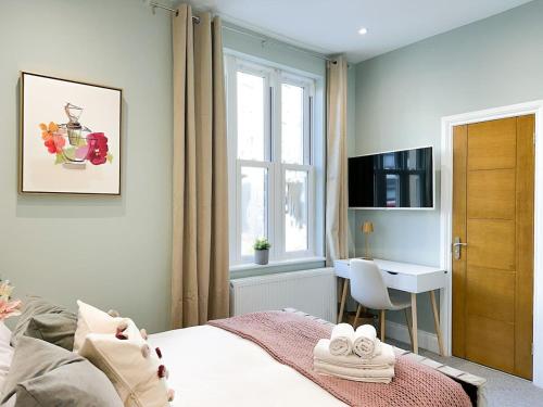 a bedroom with a bed and a desk and a window at Farringdon Rooms in London