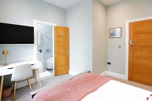 a bedroom with a bed and a desk and a television at Farringdon Rooms in London