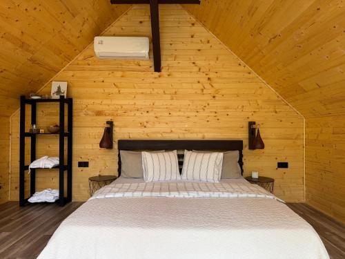a bedroom with a bed in a wooden cabin at Apusenity Resort I Piscină Interioară & Cabane în Natură in Cluj-Napoca