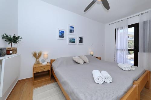 a white bedroom with a bed and a window at Hibis, No 3 in Starigrad