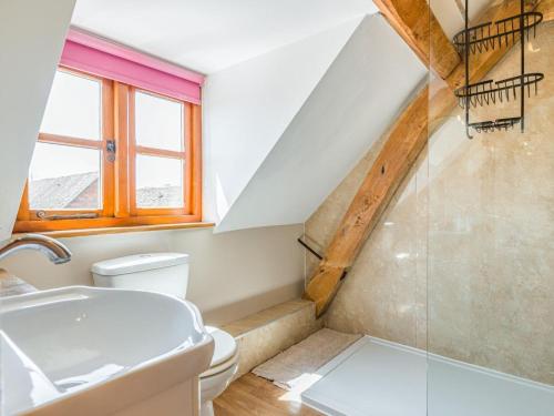 a bathroom with a sink and a toilet and a staircase at 4 Bed in Gloucester oc-41216 in Tirley