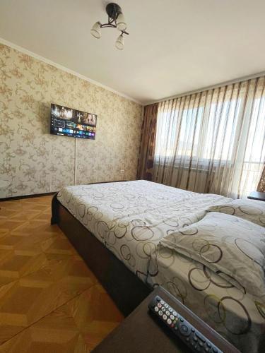 a bedroom with a bed and a remote control at Apartament Piatra Neamț Centru in Piatra Neamţ