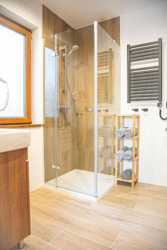 a bathroom with a shower with a glass door at Domki Białogóra in Białogóra