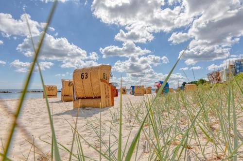 a beach with chairs and umbrellas on the sand at Luv und Lee in Schilksee
