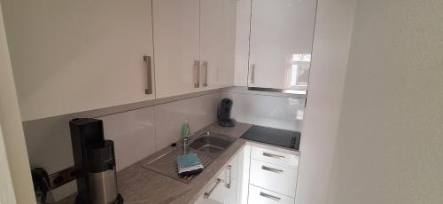 a white kitchen with a sink and a window at Ferienresort mit Pool am Schluchsee in Schluchsee