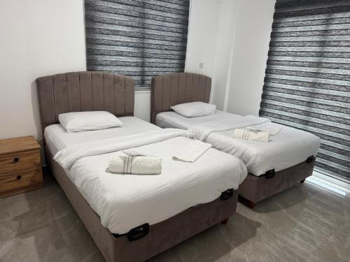 two twin beds in a room with windows at Veray Homes, Alsancak in Ayios Dhometios
