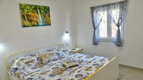 a bedroom with a bed with a painting on the wall at Apartment Daca in Vir