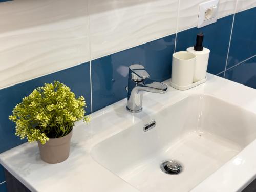 a sink with a faucet and a plant on it at Ferrera Suite & Rooms in Misterbianco