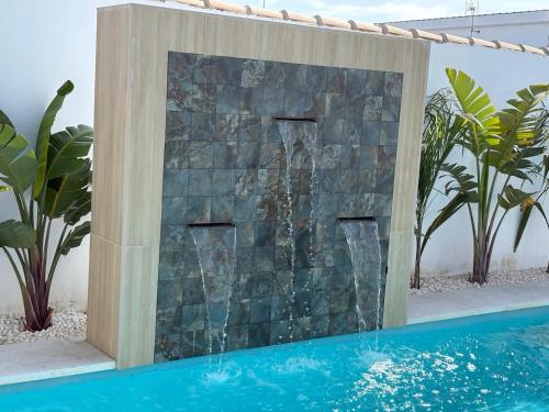 a waterfall in a stone wall next to a swimming pool at GUACAMAYOS in Cádiz