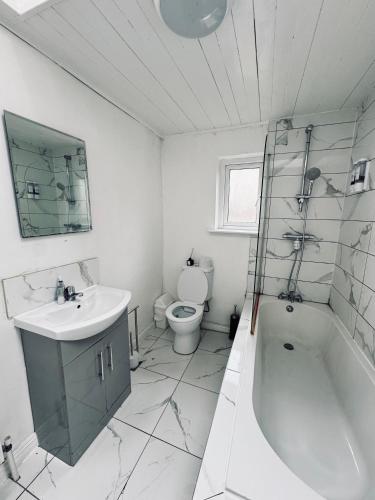a bathroom with a tub and a sink and a toilet at 13 Frankfield Terrace, Summerhill South, Cork, T12 PY79 in Cork