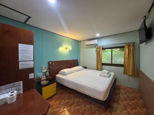a bedroom with a bed and a window at Baan Kao Kod in Nakhon Si Thammarat