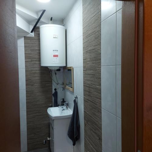 a small bathroom with a sink and a water tank at Hidden place in pure center in Novi Sad