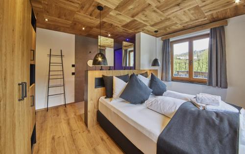 a bedroom with a large bed with a ladder at Chalet Wallehen by we rent, JOKERCARD INCLUDED in Saalbach-Hinterglemm