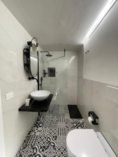 a white bathroom with a sink and a toilet at La Maison De Rennì in Viterbo