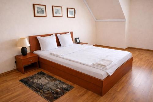 a bedroom with a large bed with white sheets at апартамент Хармония in Gotse Delchev