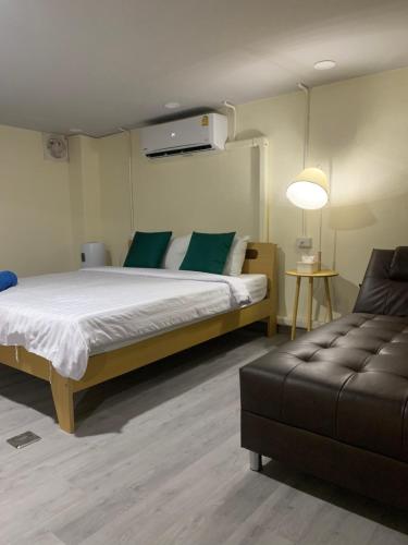a bedroom with a large bed and a couch at Uncle Yo House in Phuket