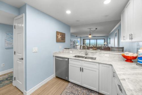 a kitchen with a sink and a counter top at Sunset Captiva Bayside Unit 103 condo in Captiva
