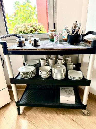 a shelf with plates and cups and dishes on it at Red House Rooms in Llucmajor