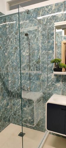 a bathroom with a glass shower with a sink at A&Bpikermistudios2 in Pikérmion